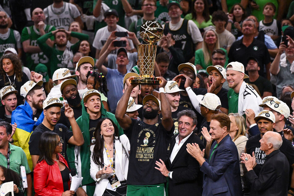 Boston Celtics guard Jaylen Brown holds up the Larry O’Brien Championship Trophy after their win against the Dallas Mavericks in the 2024 NBA Finals at TD Garden.