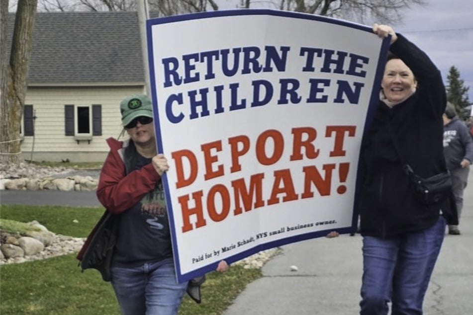 Protesters hold a sign reading "Return the Children, Deport Homan!" during a rally and march in Sackets Harbor, New York, against a local family's ICE detention.