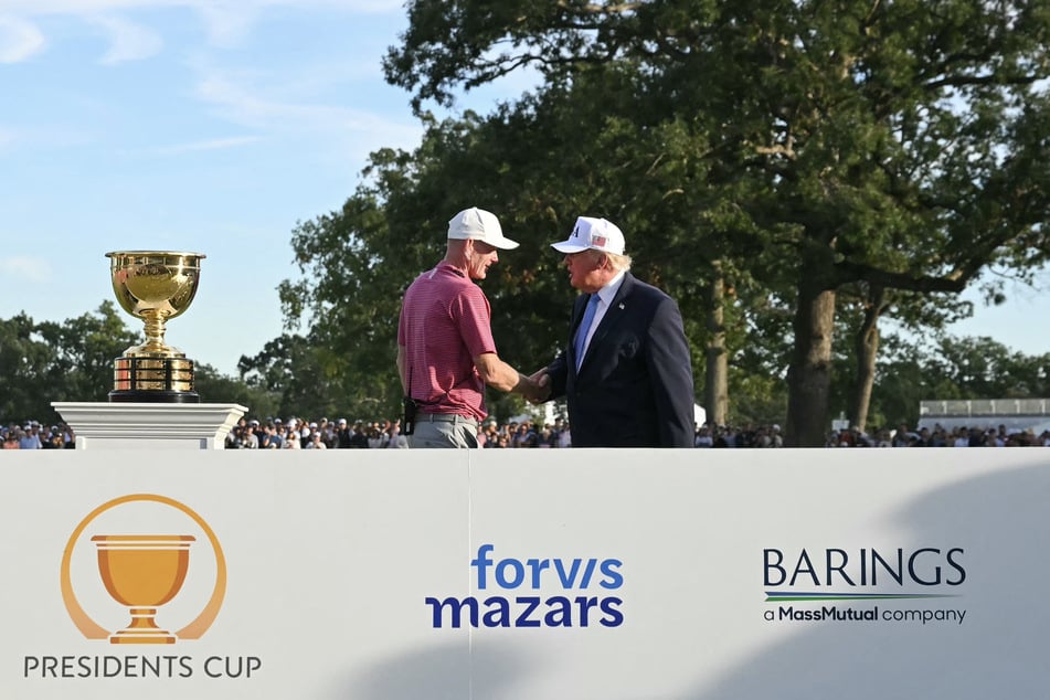 Captain Brandt Snedeker of the US team (l.) shakes hands with Donald Trump (r.) during the trophy ceremony of the President's Cup golf tournament in Medinah, Illinois, on September 27, 2026.