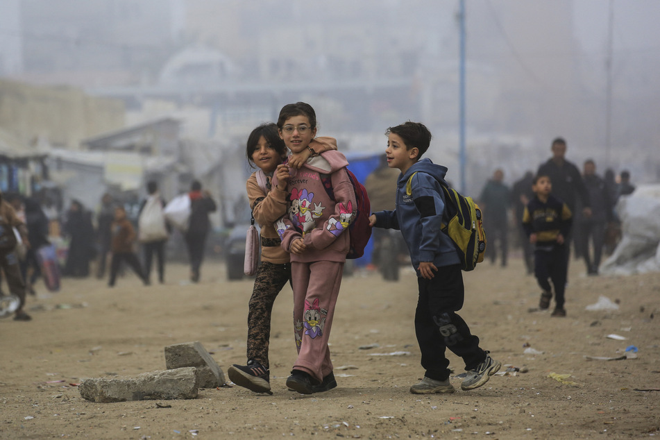Palestinian children walk down a road in Khan Younis, in the southern Gaza Strip, on February 10, 2026.