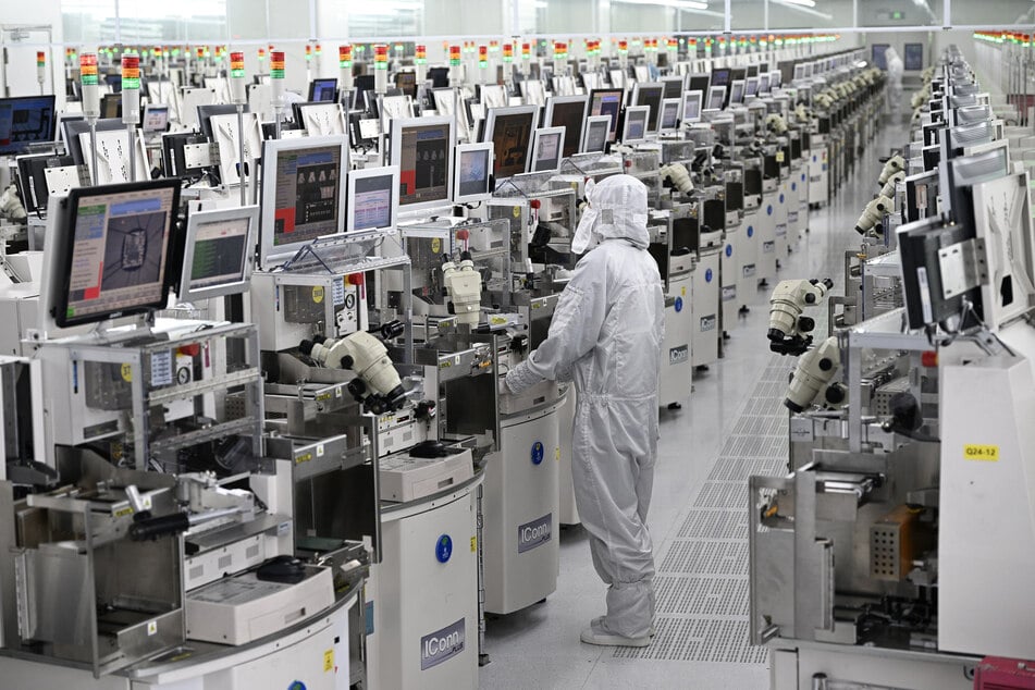A technician works on chip processing equipment at a semiconductor manufacturing plant in Suqian, in eastern China's Jiangsu province on October 20, 2025.