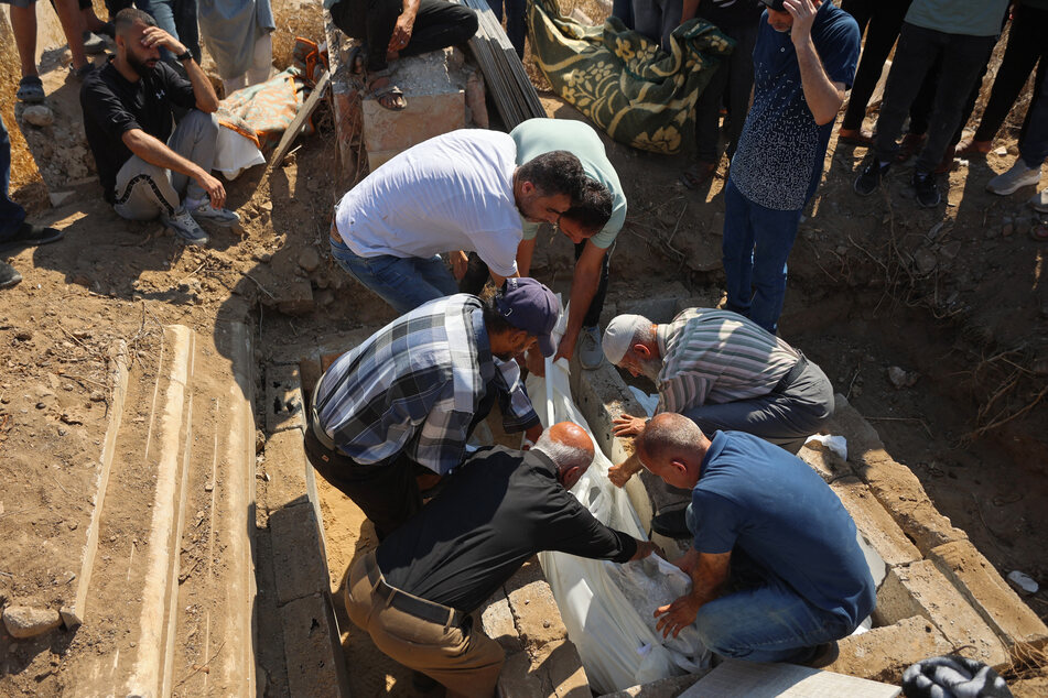 Family members bury those who died in a recent Israeli airstrike which targeted a residential apartment in the Sabra neighborhood of Gaza City.