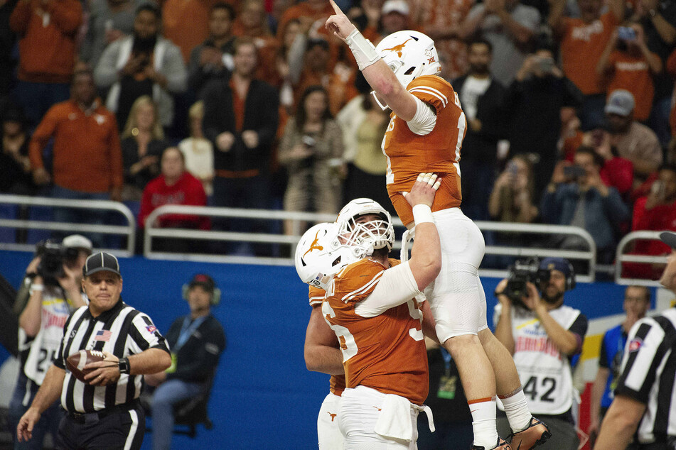 The Texas Longhorns' former quarterback Sam Ehlinger celebrates with his team at the Valero Alamo Bowl in San Antonio on December 31, 2019.