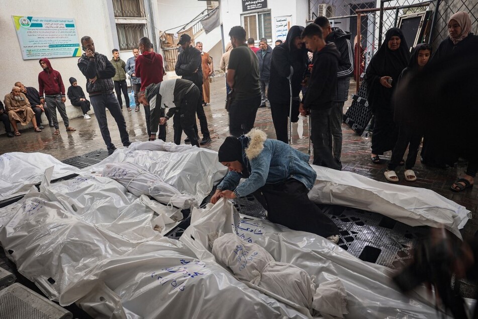 Palestinians mourn by bodies of relatives killed following overnight Israeli strikes on Rafah in the southern Gaza Strip.