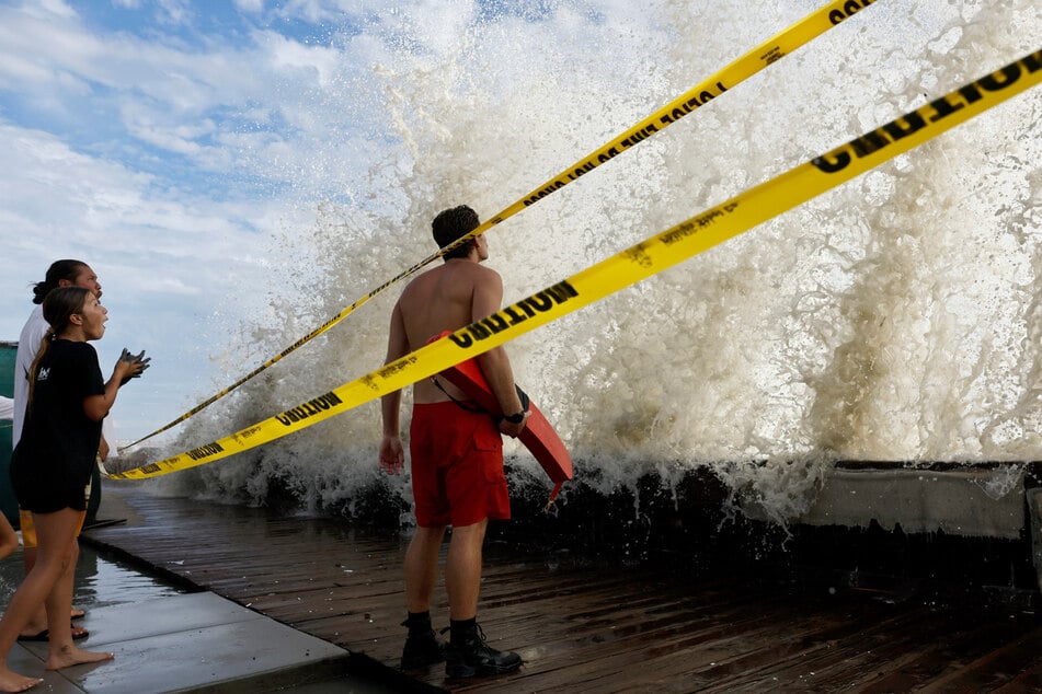 A lifeguard keeps watch along a closed boardwalk as a wave crashes over a seawall protecting homes on September 7. The emerging El Niño is believed to have contributed to severe storms like Hurricane Marie.