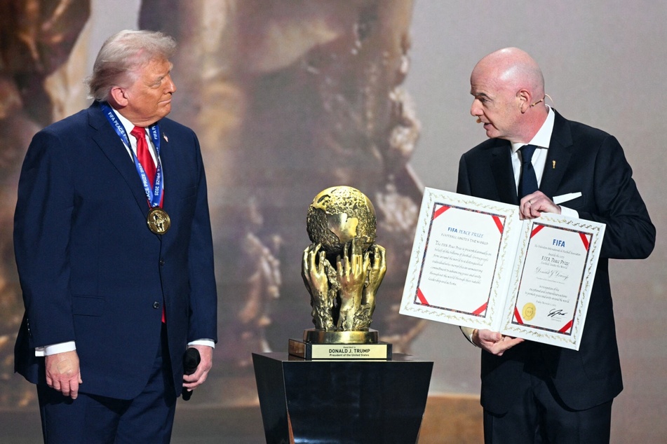 President Donald Trump (l) receives the FIFA Peace Prize from FIFA President Gianni Infantino at the Kennedy Center in Washington, DC, on December 5, 2025.