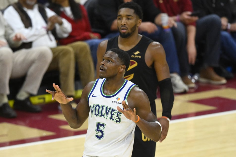 Minnesota Timberwolves guard Anthony Edwards celebrates his three-point basket beside Cleveland Cavaliers guard Donovan Mitchell in overtime at Rocket Arena.