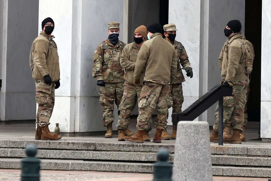 Police and National Guard stand watch over the United States Capitol building.