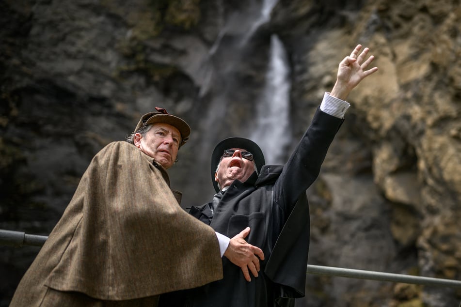 British lawyer Peter Horrocks (r.), dressed as crime lord Professor Moriarty, and British motoring author Philip Porter, dressed as Sherlock Holmes, reenact their famous duel during a visit to the Reichenbach Falls near Meiringen on May 3, 2026.