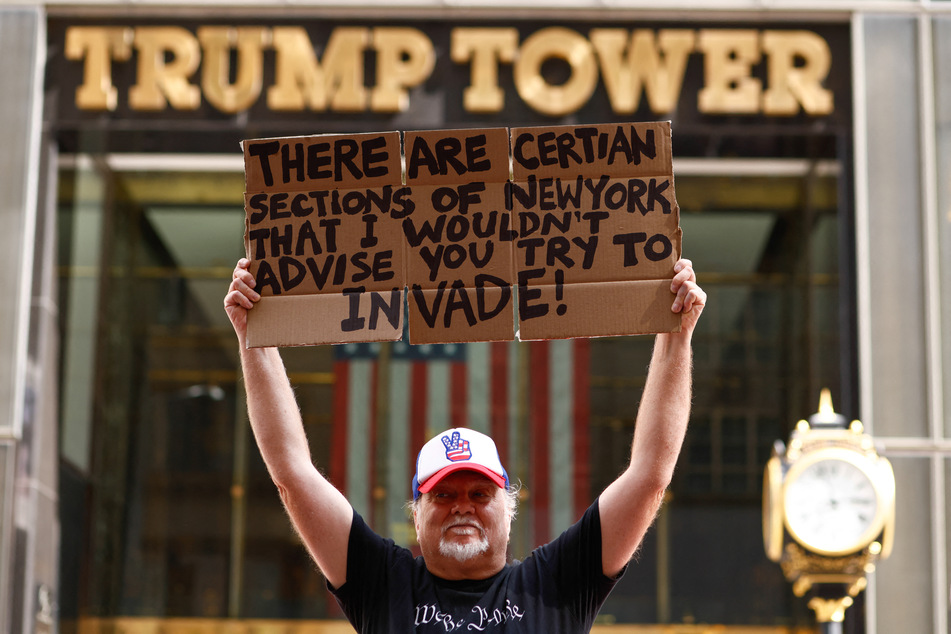 A man holds a sign as people demonstrate during a Labor Day "Workers Over Billionaires" rally outside Trump Tower in New York City on September 1, 2025.