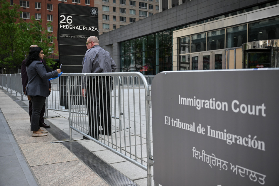 A security guard speaks to people at the entrance to the US Immigration and Customs Enforcement building at 26 Federal Plaza on May 8, 2025, in New York City.