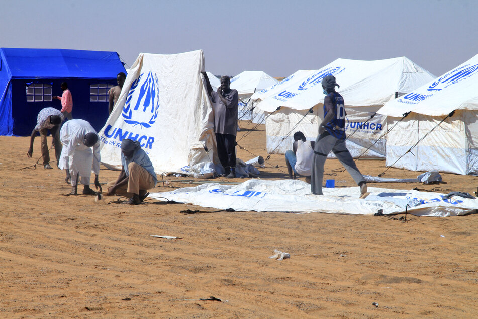 Sudanese volunteers prepare tents for those who fled El-Fasher at the Al-Afad camp for displaced people in the town of Al-Dabba, northern Sudan, on November 20, 2025.