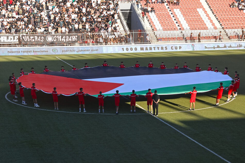 A Palestinian flag is displayed on the field before the start of the soccer match between Jabal Al-Mukaber and Shabab Al-Khalil during the 1,000 Martyrs' Cup tournament at the Faisal Al-Husseini International Stadium in the West Bank city of Al-Ram on September 4, 2026.