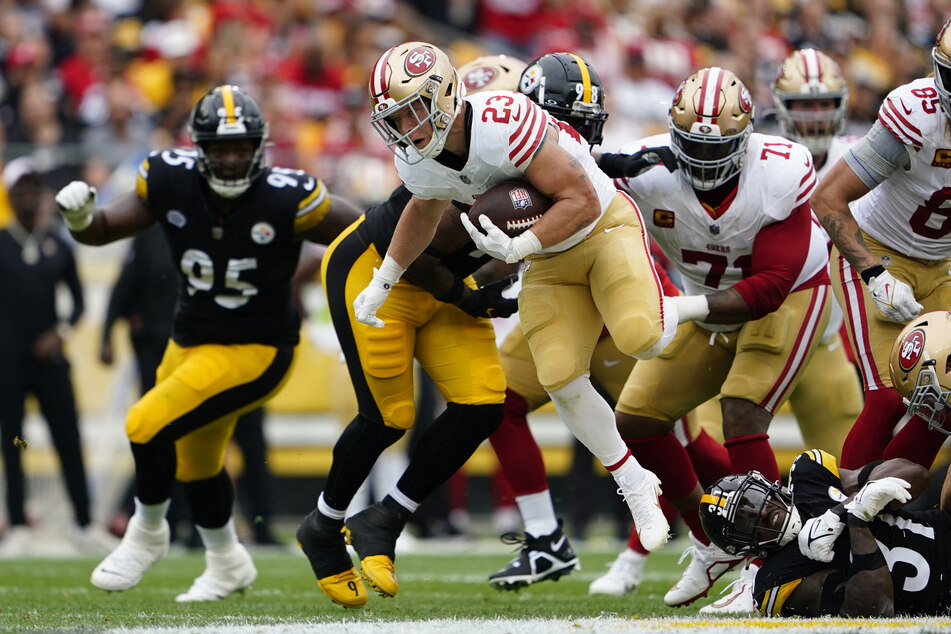 San Francisco 49ers running back Christian McCaffrey runs through the line against the Pittsburgh Steelers during the first half at Acrisure Stadium.