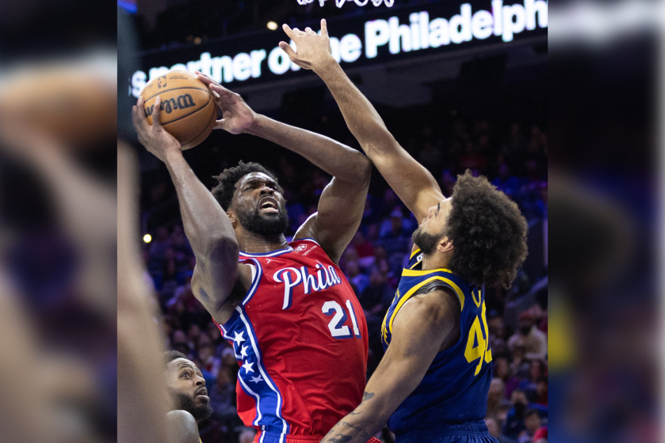 Philadelphia 76ers center Joel Embiid (l.) drove past Golden State Warriors forward Anthony Lamb on Friday night.