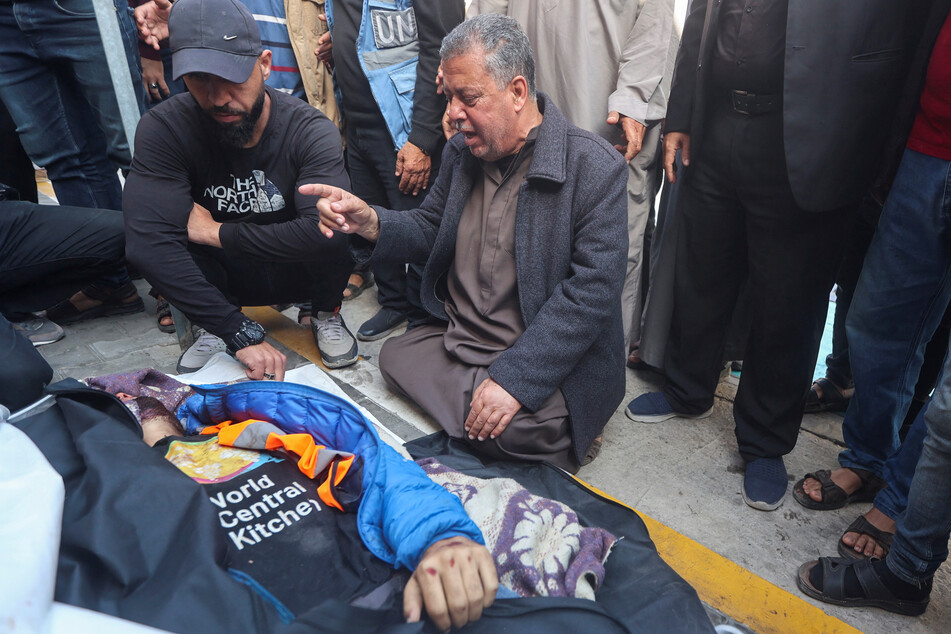 Mourners gather around the body of Palestinian aid worker Issam Abu Taha, a volunteer with the World Central Kitchen, who was killed in an Israeli airstrike.