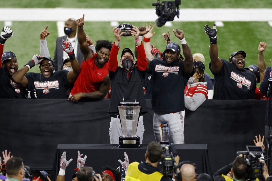 Ohio State Buckeyes head coach Ryan Day holds up the championship trophy alongside MVP Trey Sermon after defeating the Northwestern Wildcats 22-10 in the Big Ten Championship.