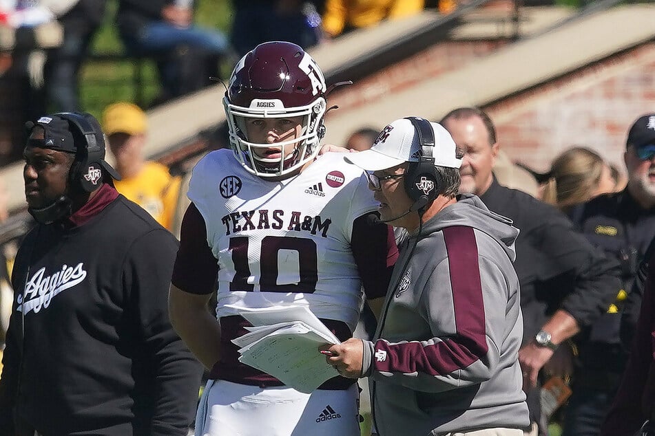 Texas A&M head coach Jimbo Fisher (r.) talks with quarterback Zach Calzada (l.).
