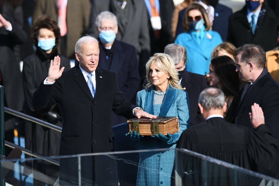 President Joe Biden reciting the oath of office, while Dr. Jill Biden holds the family Bible.