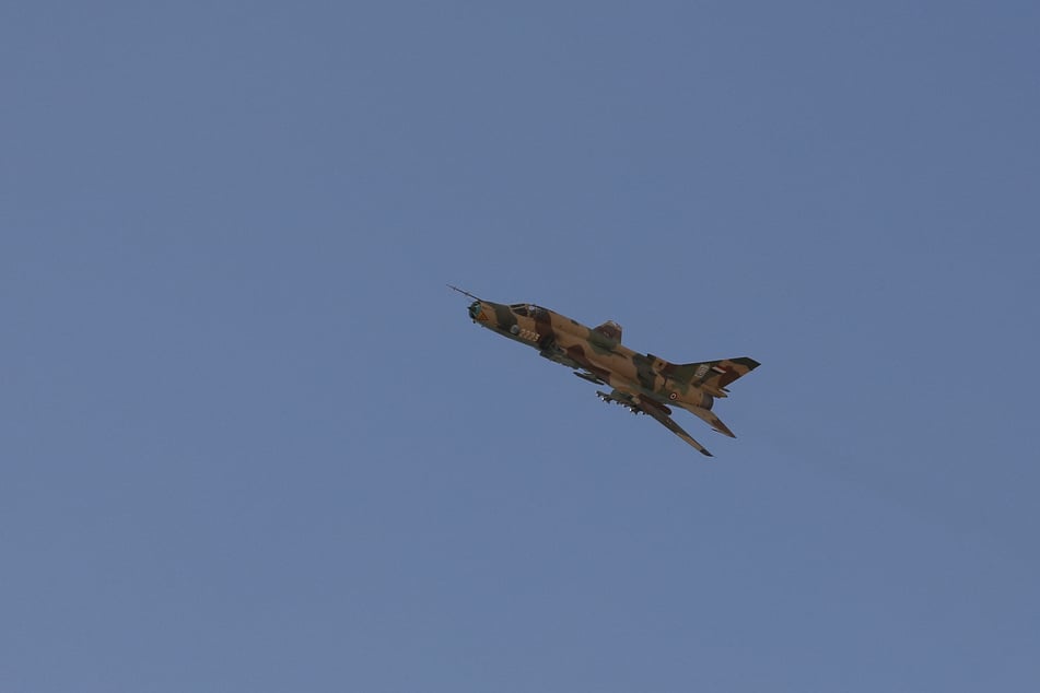 A Houthi-operated fighter jet flies as Yemenis rally to commemorate 10 Houthi fighters killed by the US Navy in the Red Sea.