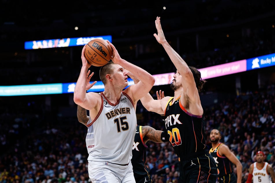 Denver Nuggets center Nikola Jokic looks to shoot against Phoenix Suns forward Dario Saric in the third quarter at Ball Arena.