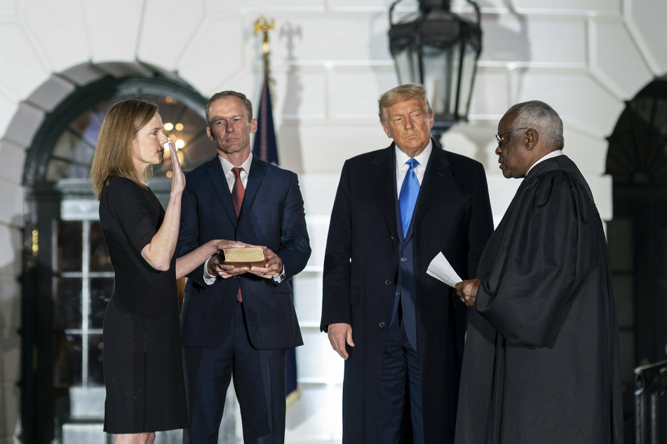 Justice Amy Coney Barrett, seen here being sworn in by Justice Clarence Thomas, did not take part in the deliberations.