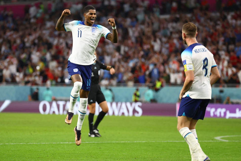 England's Marcus Rashford (l.) celebrates scoring their third goal with Jordan Henderson.
