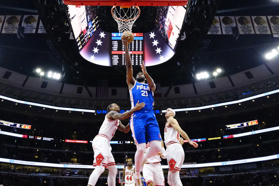 Philadelphia 76ers center Joel Embiid scores as Chicago Bulls forward DeMar DeRozan defends him during the first half at United Center.
