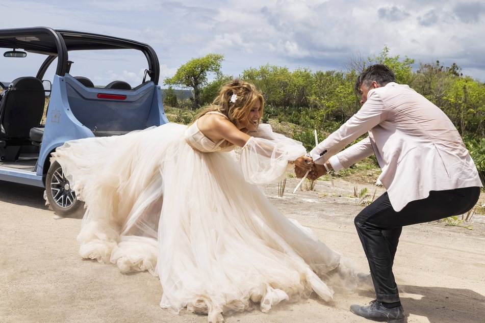 Jennifer Lopez (l) and Josh Duhamel must save their wedding guests while trying not to kill each other in the upcoming movie, Shotgun Wedding.