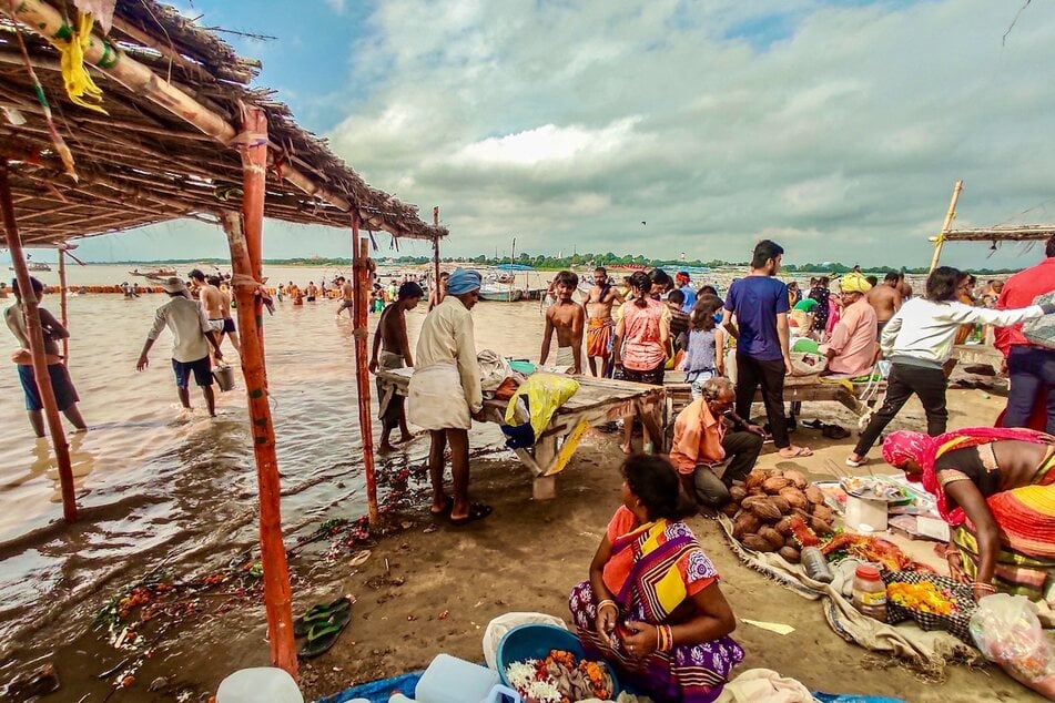 Rising river levels cause people to move possessions in Prayagraj district, India.