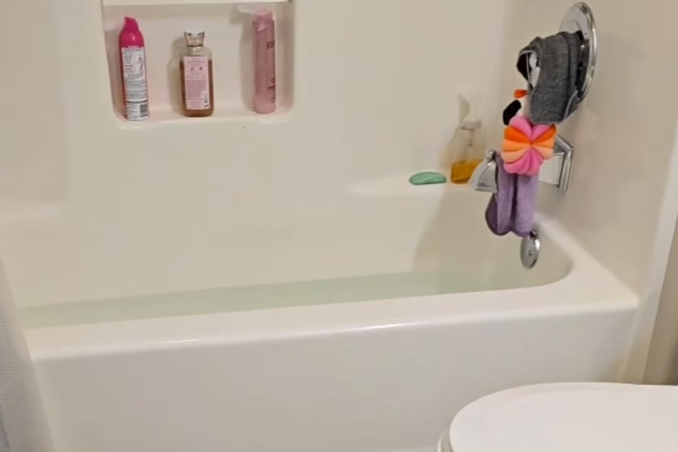Slimy fingers reach out of the bathtub drain in squirm-inducing animal encounter