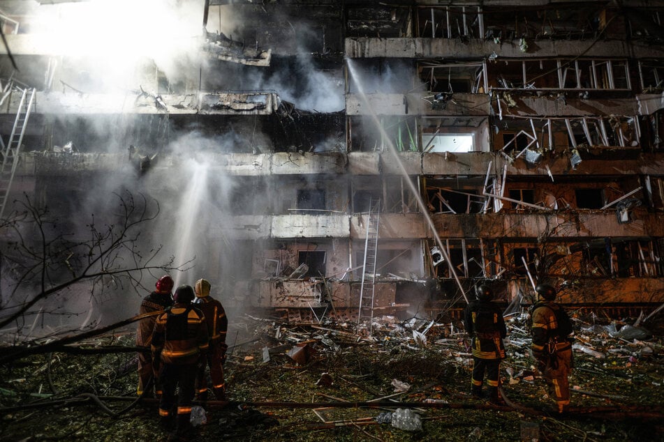 Ukrainian firefighters extinguish a blaze at the site of a Russian missile strike at an apartment building in Kyiv on October 14, 2026.
