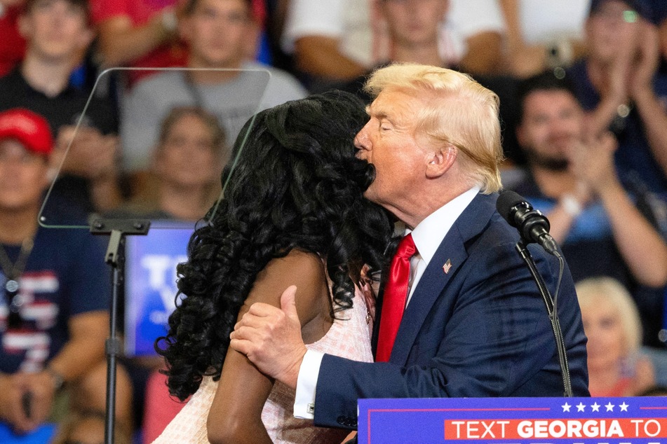 Republican presidential candidate Donald Trump sharing a kiss with activist Michaelah Montgomery during a campaign rally in Atlanta, Georgia on August 3, 2024.