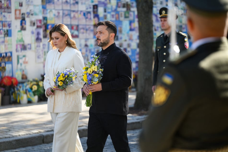 Ukraine's President Volodymyr Zelensky (c.) and his wife Olena Zelenska (l.) lay flowers at the Wall of Remembrance in Kyiv on the Independence Day of Ukraine on August 24, 2026.