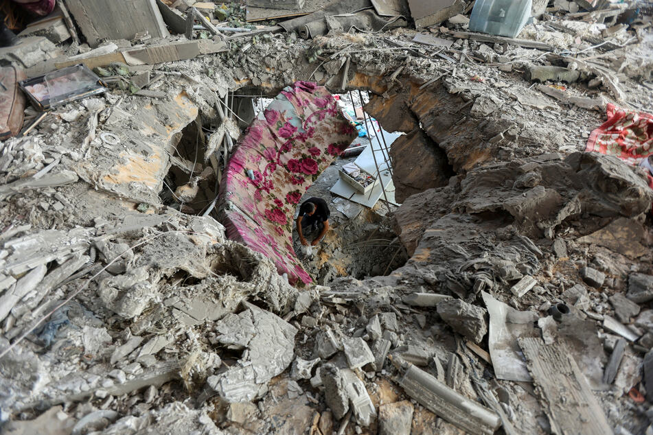 A Palestinian man inspects a house hit in an Israeli strike in Bureij refugee camp in the central Gaza Strip's Deir Al-Balah governorate.