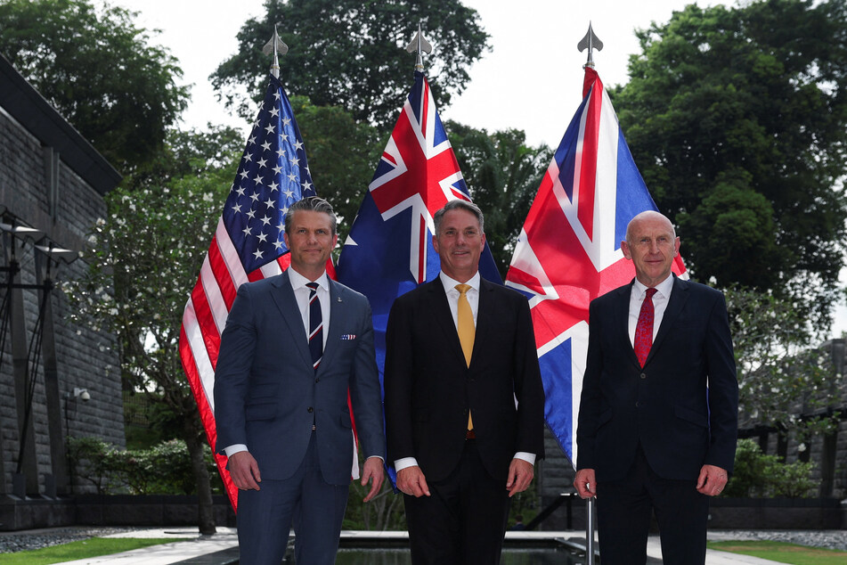 From l. to r.: US Defense Secretary Pete Hegseth, Australian Defense Minister Richard Marles, and British Defense Secretary John Healey pose during an AUKUS Defense ministers' press huddle at the US Embassy in Singapore on May 30, 2026.