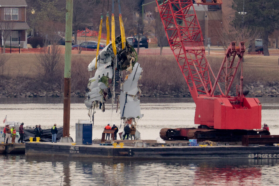 A large portion of the damaged plane fuselage is lifted from the Potomac River during recovery efforts after the American Airlines crash on February 3, 2025 in Arlington, Virginia.