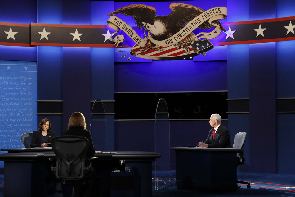 Vice President Mike Pence (r.) watches opponent Kamala Harris give a response.