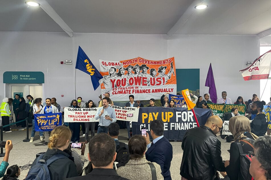 Activists with banners and flags hold a gathering to demand that rich countries help developing nations tackle global warming, during the UN Climate Change Conference (COP29) in Baku, Azerbaijan, on November 21, 2024.