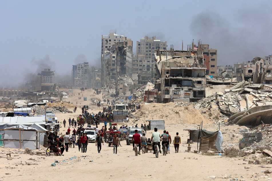 Palestinians transport their belongings as they flee the northern Gaza Strip toward the south along the coastal al-Rashid road on May 25, 2025.