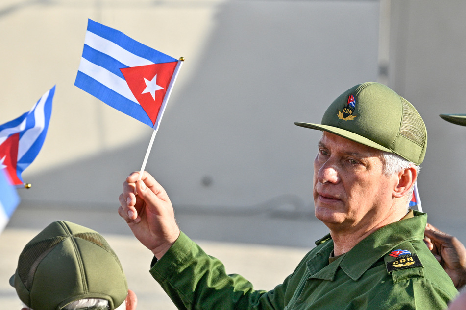 President Miguel Diaz-Canel holds a Cuban flag during a rally in support of former president Raul Castro, after his indictment, outside the US Embassy in Havana on May 22, 2026.