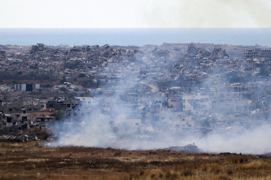 This picture taken from Israel's southern border shows burning fields in front of destroyed houses in northern Gaza on May 4, 2025.