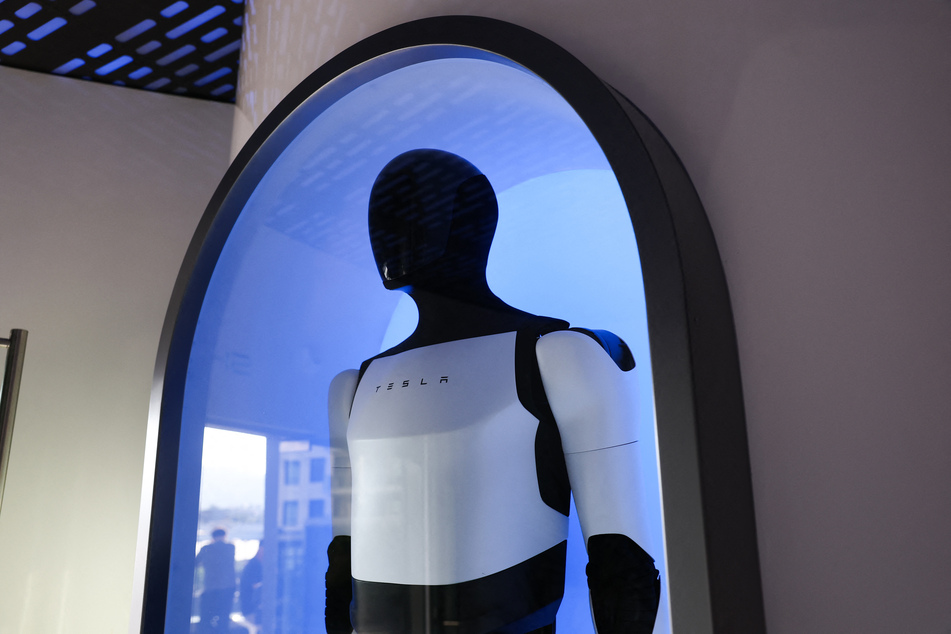 An Optimus robot is displayed during the opening of the Tesla Diner and Drive-In restaurant and Supercharger on Santa Monica Blvd in Los Angeles, California, on July 21, 2025.