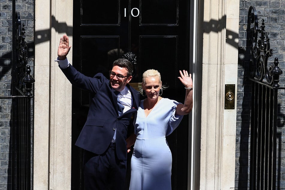 Prime Minister Andy Burnham and his wife Marie-France van Heel pose at the door of 10 Downing Street after taking office.