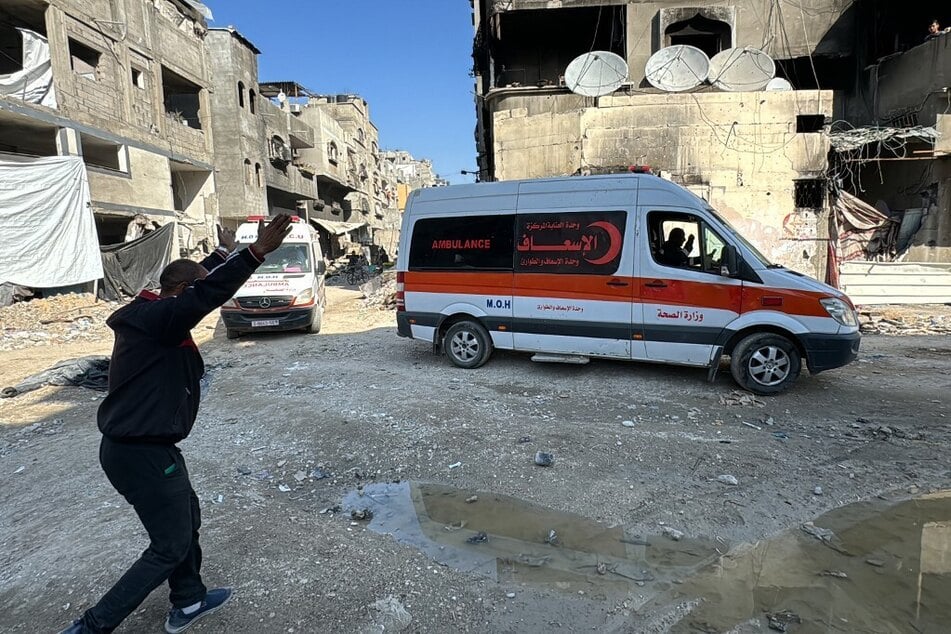 A Palestinian man gestures toward ambulances transporting victims of Israeli bombing to the Kamal Adwan hospital in Beit Lahia in the northern Gaza Strip.
