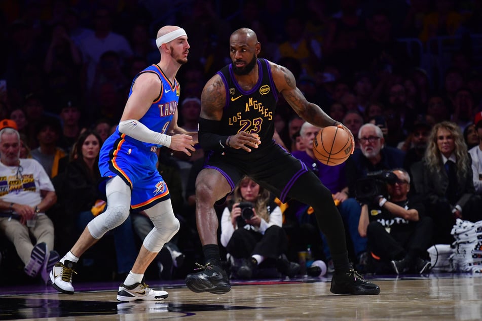 LeBron James moves the ball against Oklahoma City Thunder guard Alex Caruso during the second half in game four of the second round of the 2026 NBA Playoffs at Crypto.com Arena.