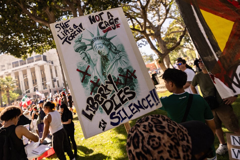 Demonstrators hold a poster depicting a crying Statue of Liberty during the "No Kings" national day of protest in Los Angeles on March 28, 2026.