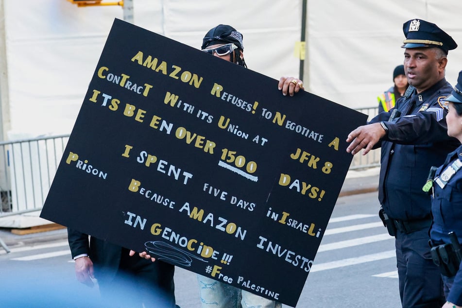 Chris Smalls is pictured with a protest sign denouncing Amazon's support for Israel's genocide outside the Met Gala on May 4, 2026.