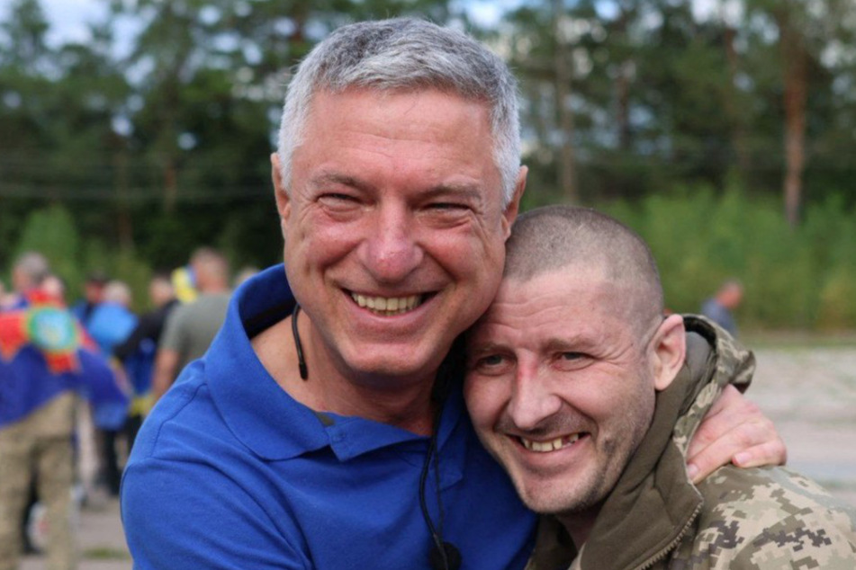 A staff member of the Coordination Headquarters for the Treatment of Prisoners (l.) embraces a Ukrainian prisoner of war following an exchange of prisoners on Sunday.