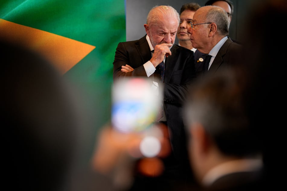 Brazilian President Luiz Inácio Lula da Silva speaks with an aid as he arrives for a press conference at the Brazilian Embassy in Washington, DC.